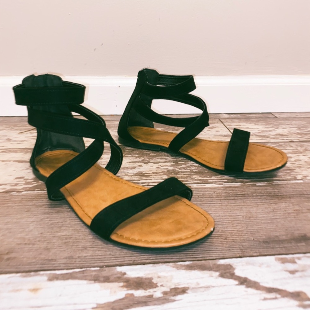 Black cross sandals with a brown bottom.